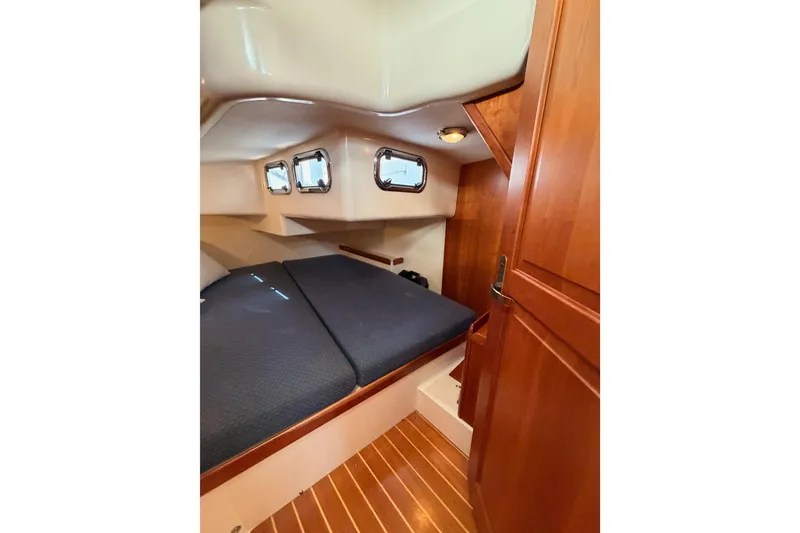 Slide: The Image of Cozy cabin interior of 2002 Tartan 3700 sailboat with wooden finishes and porthole windows. - 74