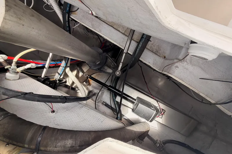 Slide: The Image of Engine compartment of a 2002 Tartan 3700 sailboat, showcasing cables and mechanical components. - 105