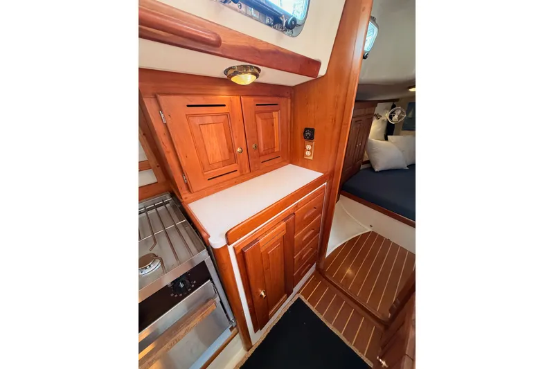 Slide: The Image of Interior of 2002 Tartan 3700 sailboat with wooden cabinetry and compact kitchen area. - 69