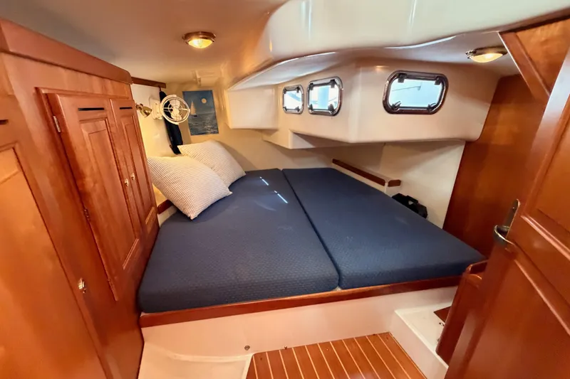 Slide: The Image of Cozy cabin interior of 2002 Tartan 3700 yacht with wooden furnishings and blue bedding. - 73