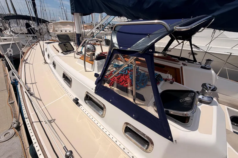 Slide: The Image of 2002 Tartan 3700 sailboat docked, featuring sleek deck design and nautical equipment. - 16