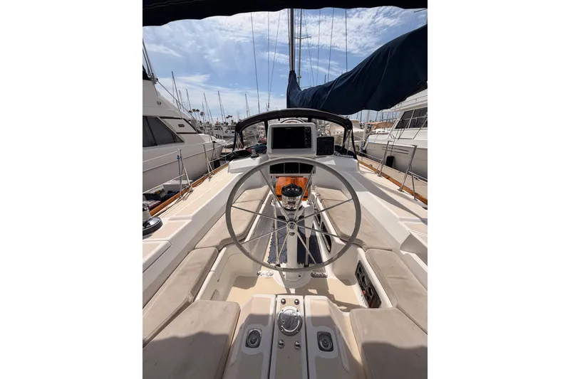 Slide: The Image of Cockpit view of a 2002 Tartan 3700 sailboat, featuring a steering wheel and navigation equipment. - 36