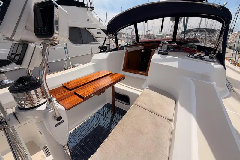 Slide: The Image of Cockpit of 2002 Tartan 3700 sailboat with wooden table and navigation equipment. - 42