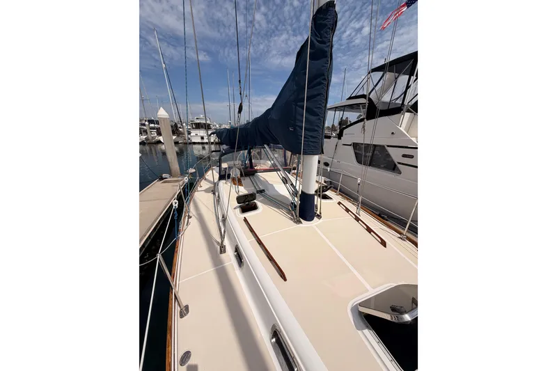 Slide: The Image of 2002 Tartan 3700 sailboat docked at marina under blue sky. - 23