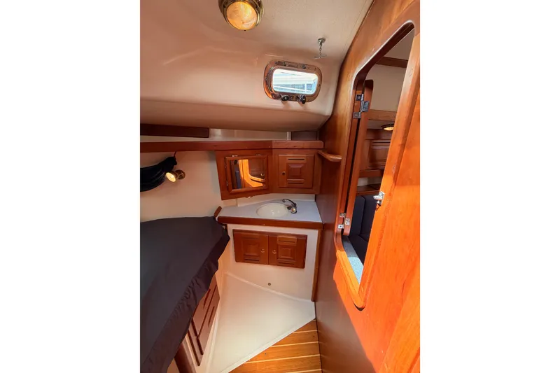 Slide: The Image of Interior of 2002 Tartan 3700 sailboat with wooden cabinetry and compact sink area. - 91