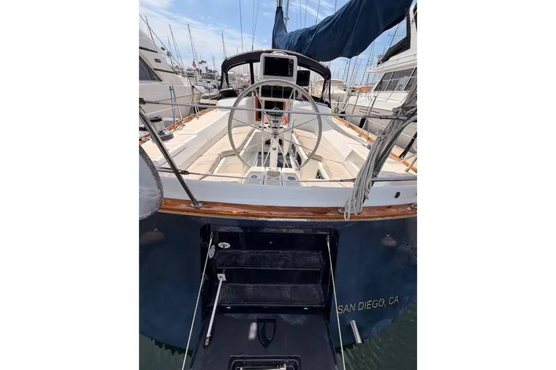 Slide: The Image of 2002 Tartan 3700 sailboat docked in San Diego marina, featuring a spacious cockpit. - 35
