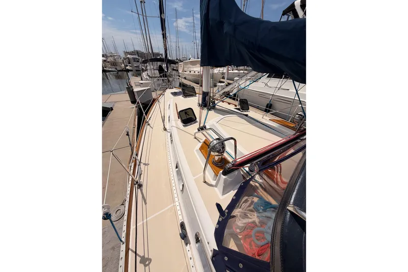 Slide: The Image of 2002 Tartan 3700 sailboat docked at marina, showcasing deck and rigging. - 17