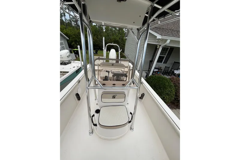 Slide: The Image of 2020 Carolina Skiff 21 LS boat interior with seating and console, parked near a house. - 5