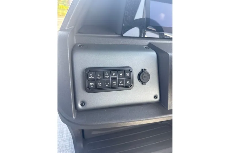 Slide: The Image of Control panel of 2026 Sun Tracker Sportfish 24 XP3 boat with labeled switches. - 12