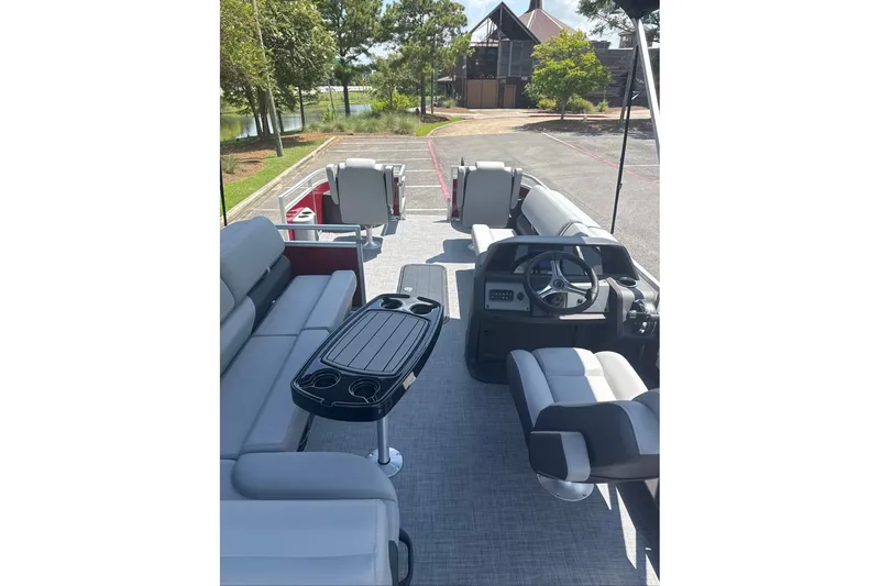 Slide: The Image of 2026 Sun Tracker Sportfish 24 XP3 pontoon boat interior with seating and steering console. - 10
