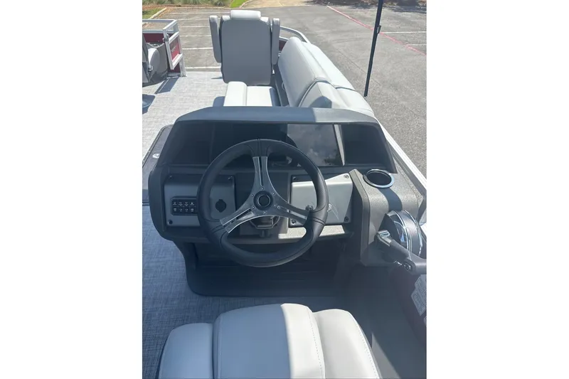 Slide: The Image of 2026 Sun Tracker Sportfish 24 XP3 boat dashboard with steering wheel and controls. - 11