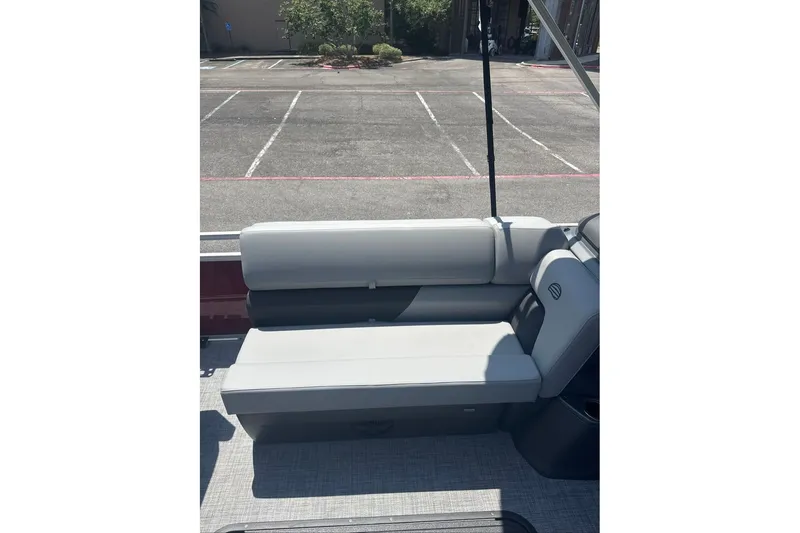 Slide: The Image of 2026 Sun Tracker Sportfish 24 XP3 boat interior with gray seating in a parking lot. - 7