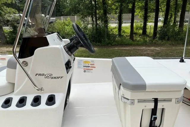 Slide: The Image of 2026 Mako Pro Skiff 15 CC boat interior with steering console and cushioned seat. - 6