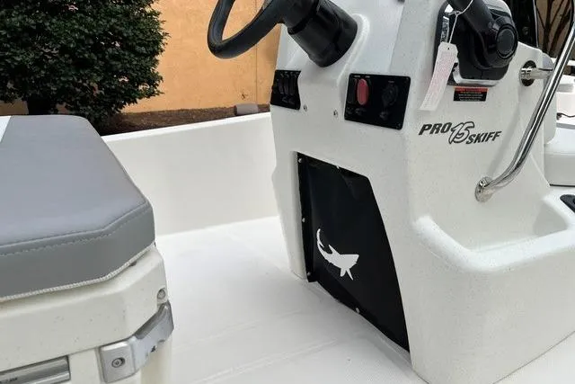Slide: The Image of 2026 Mako Pro Skiff 15 CC boat interior with steering console and seating. - 13
