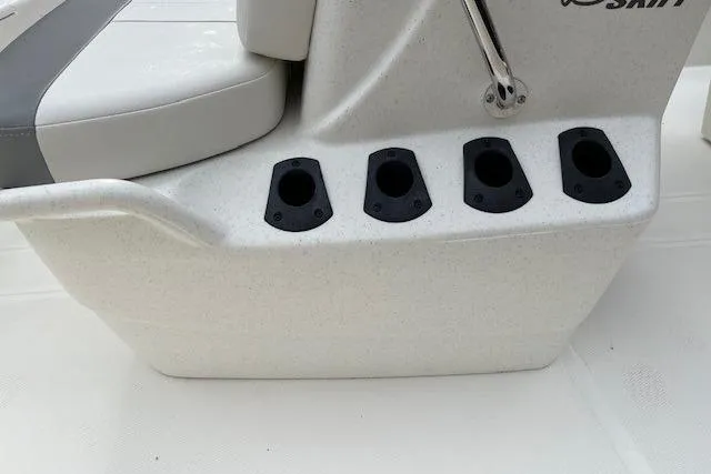 Slide: The Image of 2026 Mako Pro Skiff 15 CC boat seat with rod holders, white and gray design. - 12