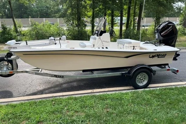 Slide: The Image of 2026 Mako Pro Skiff 15 CC boat on trailer, parked outdoors. - 1
