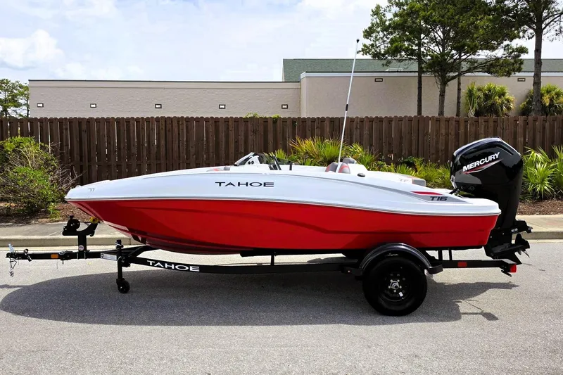 Slide: The Image of 2026 Tahoe T16 boat with red hull on trailer, parked outdoors. - 8