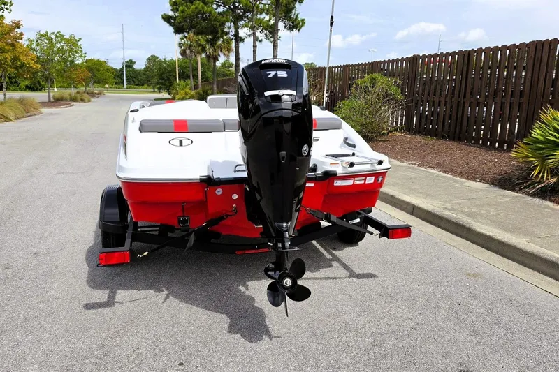 Slide: The Image of 2026 Tahoe T16 boat with 75 HP engine on trailer, parked on a road. - 12