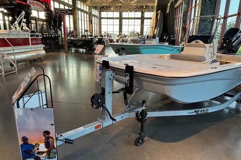 Slide: The Image of 2026 Mako Pro Skiff 13 CC boat displayed in a showroom with trailer. - 3