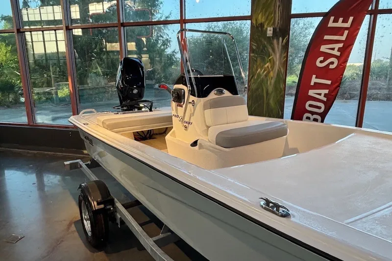 Slide: The Image of 2026 Mako Pro Skiff 13 CC boat on display in showroom with sale banner. - 5