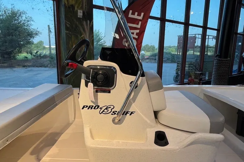 Slide: The Image of 2026 Mako Pro Skiff 13 CC boat interior with steering wheel and seating. - 6