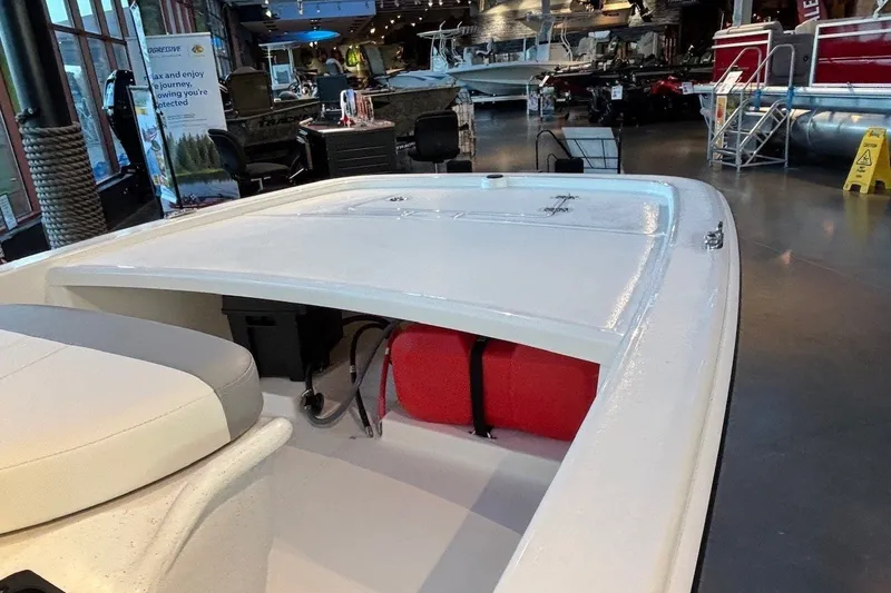 Slide: The Image of 2026 Mako Pro Skiff 13 CC boat interior in showroom, featuring seating and storage. - 7