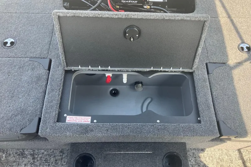 Slide: The Image of Open storage compartment in 2026 Tracker Targa V-19 Combo boat, featuring carpeted interior. - 11