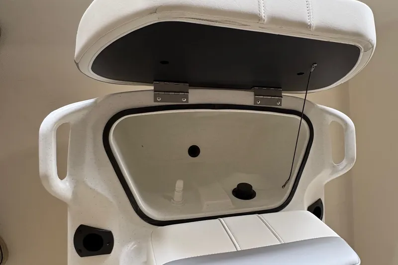 Slide: The Image of An open storage compartment with a cushioned seat on a Mako Pro Skiff 17 CC boat. - 11