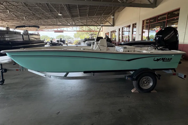 Slide: The Image of A 2026 Mako Pro Skiff 17 CC is in a showroom. It features an outboard motor. - 2