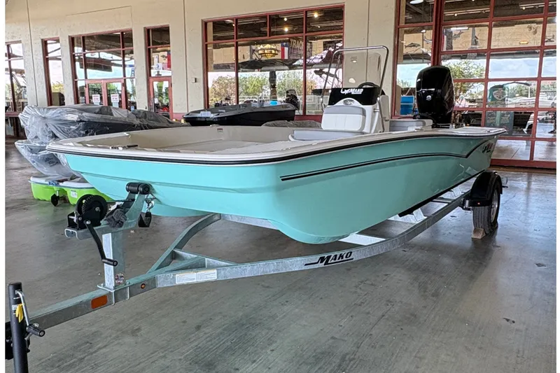 The Image of A turquoise 2026 Mako Pro Skiff 17 CC sits on a trailer in a showroom. - 0