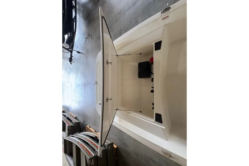 Slide: The Image of 2026 Mako Pro Skiff 17 CC boat interior with open storage compartment. - 12