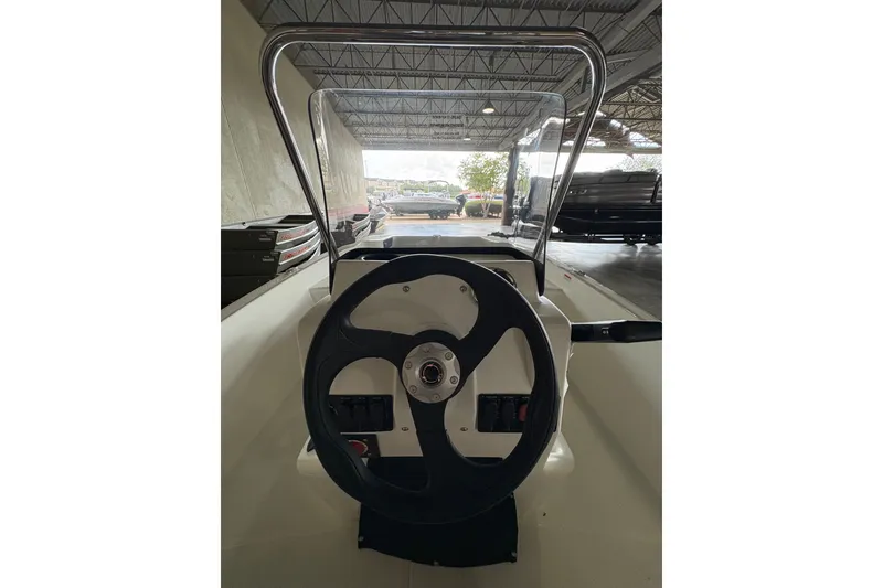 Slide: The Image of Steering console of 2026 Mako Pro Skiff 17 CC in a showroom setting. - 62