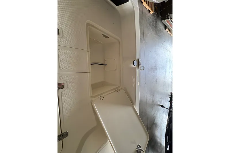 Slide: The Image of Open storage compartment on 2026 Mako Pro Skiff 17 CC boat, showcasing interior space. - 14