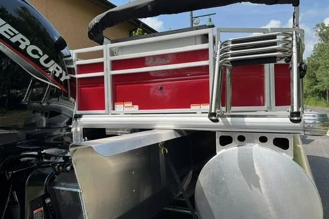 Slide: The Image of 2026 Sun Tracker SportFish 22 XP3 boat rear view with Mercury engine, red and silver design. - 6