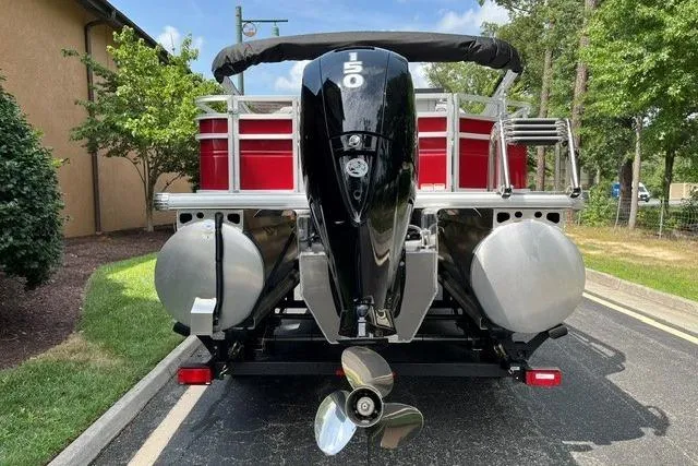 Slide: The Image of 2026 Sun Tracker SportFish 22 XP3 pontoon boat with powerful outboard motor, parked outdoors. - 3