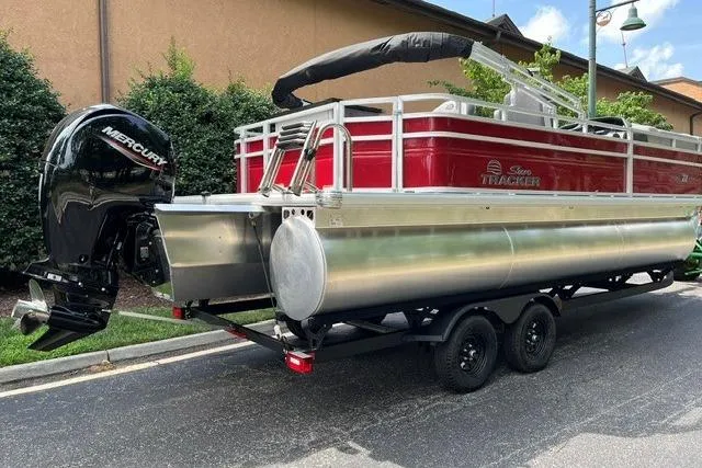 Slide: The Image of 2026 Sun Tracker SportFish 22 XP3 pontoon boat with Mercury outboard engine on trailer. - 4