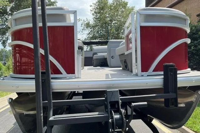 Slide: The Image of 2026 Sun Tracker SportFish 22 XP3 pontoon boat on trailer, featuring red and white design. - 2