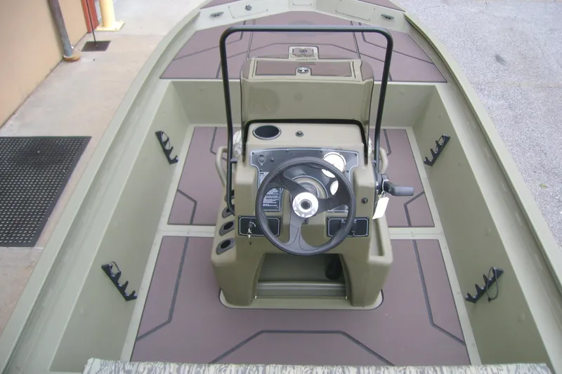 Slide: The Image of 2026 Tracker Grizzly 1860 CC boat interior with steering console and seating area. - 9