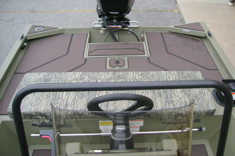 Slide: The Image of 2026 Tracker Grizzly 1860 CC boat interior with steering console and camouflage seating. - 11