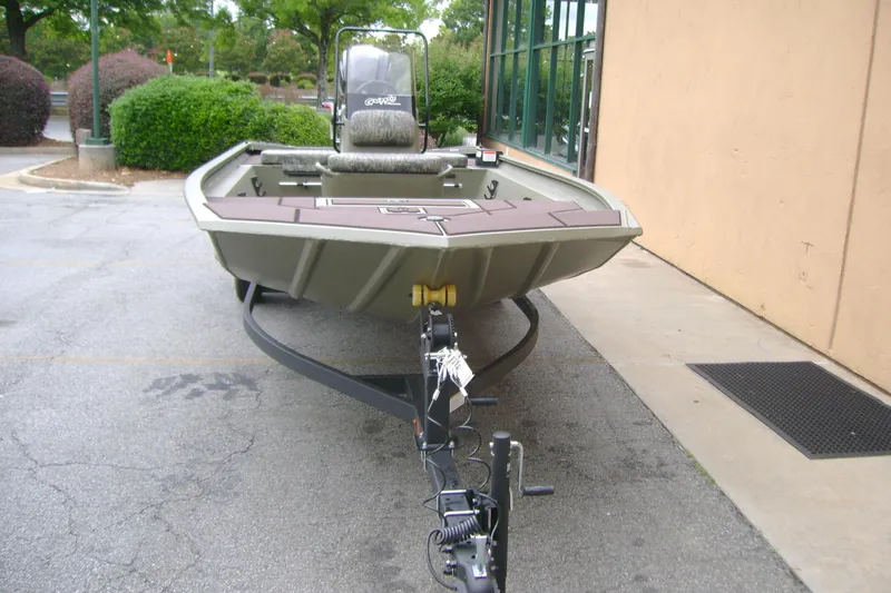 Slide: The Image of 2026 Tracker Grizzly 1860 CC boat on trailer, parked outdoors near building. - 6
