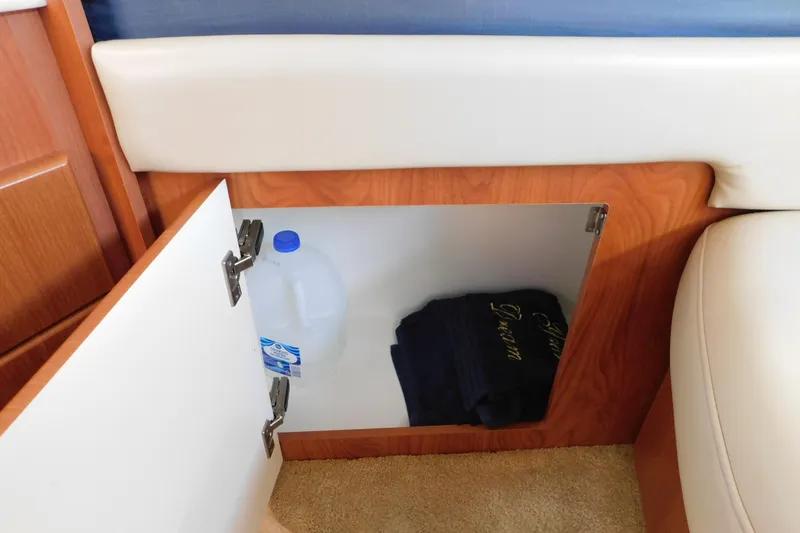 Slide: The Image of Storage compartment in 2009 Bayliner 300 boat with water jug and towels. - 72