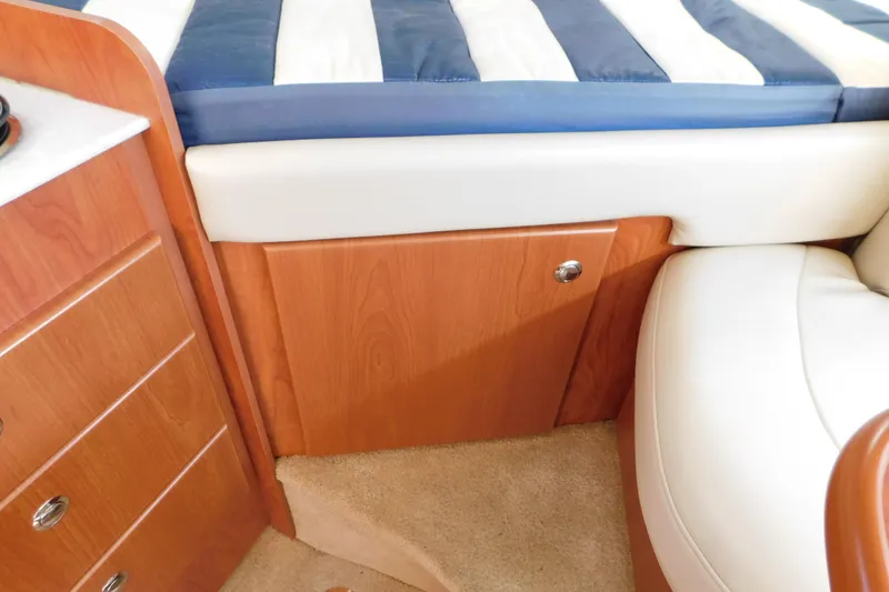 Slide: The Image of Interior of 2009 Bayliner 300 boat with wood cabinetry and striped bedding. - 71