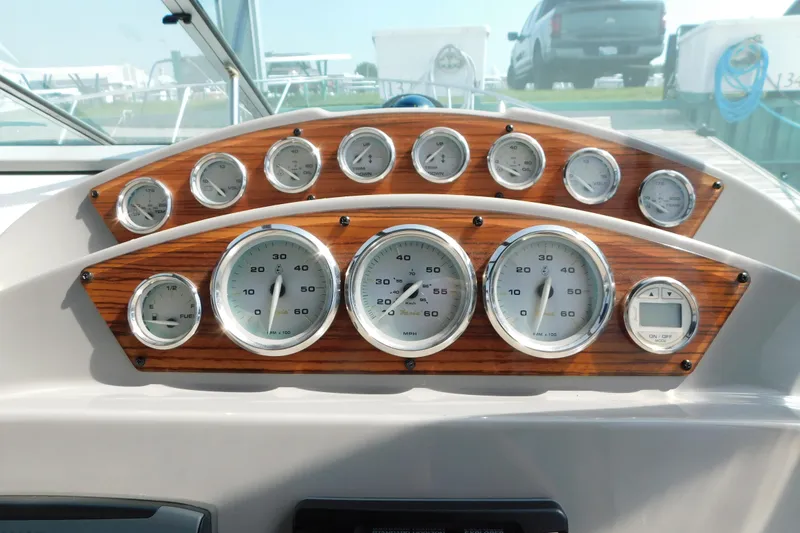 Slide: The Image of Dashboard of a 2009 Bayliner 300 boat with wood paneling and multiple gauges. - 35