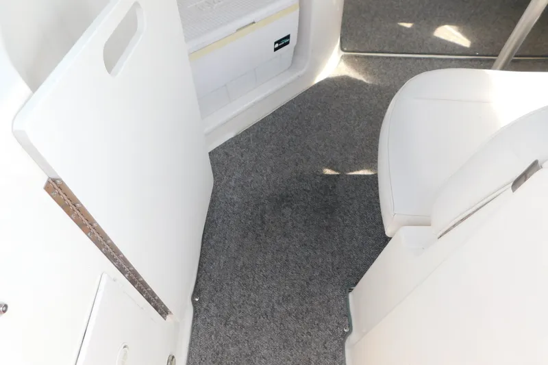 Slide: The Image of Interior view of a 2009 Bayliner 300 boat with carpeted flooring and white seating. - 18
