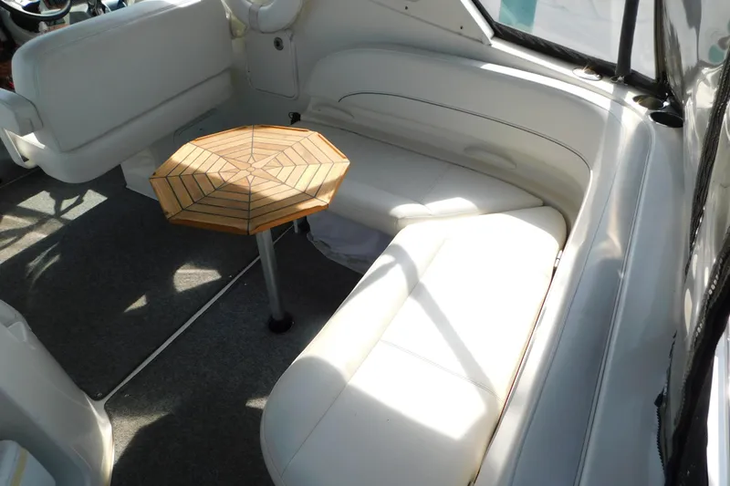 Slide: The Image of Interior of 2009 Bayliner 300 boat with white seating and wooden table. - 20