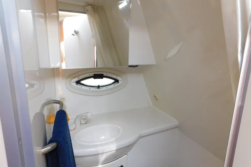 Slide: The Image of 2009 Bayliner 300 boat bathroom with sink, mirror, and porthole window. - 86
