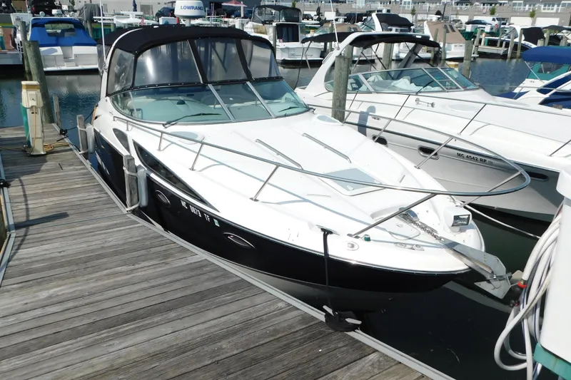 Slide: The Image of 2009 Bayliner 300 boat docked at marina, featuring sleek design and black hull. - 3