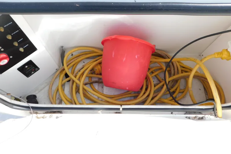 Slide: The Image of Storage compartment of 2009 Bayliner 300 with yellow cables and red bucket. - 14