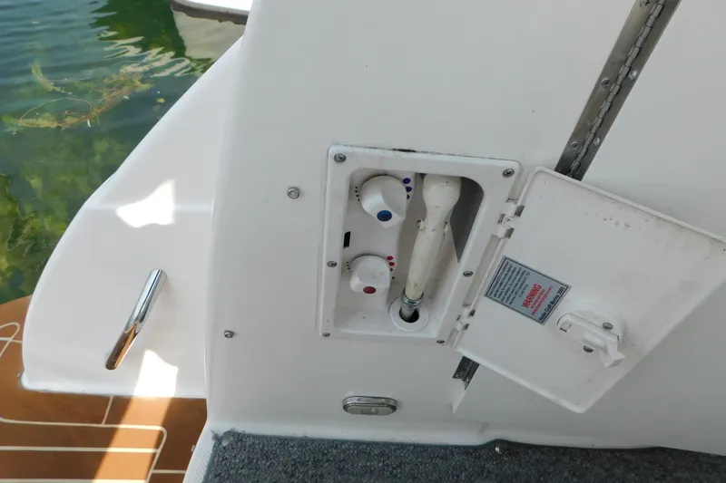 Slide: The Image of 2009 Bayliner 300 boat shower controls with open panel near water. - 17