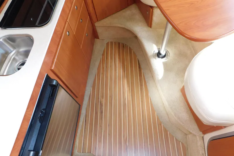 Slide: The Image of Interior of 2009 Bayliner 300 boat with wood flooring and kitchenette. - 51
